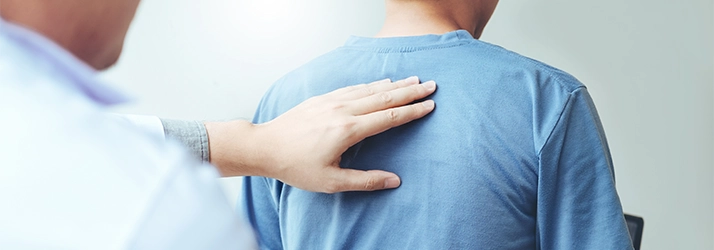 Chiropractic Shelby Charter Township MI Back Exam Patient in a blue shirt receiving a back exam.